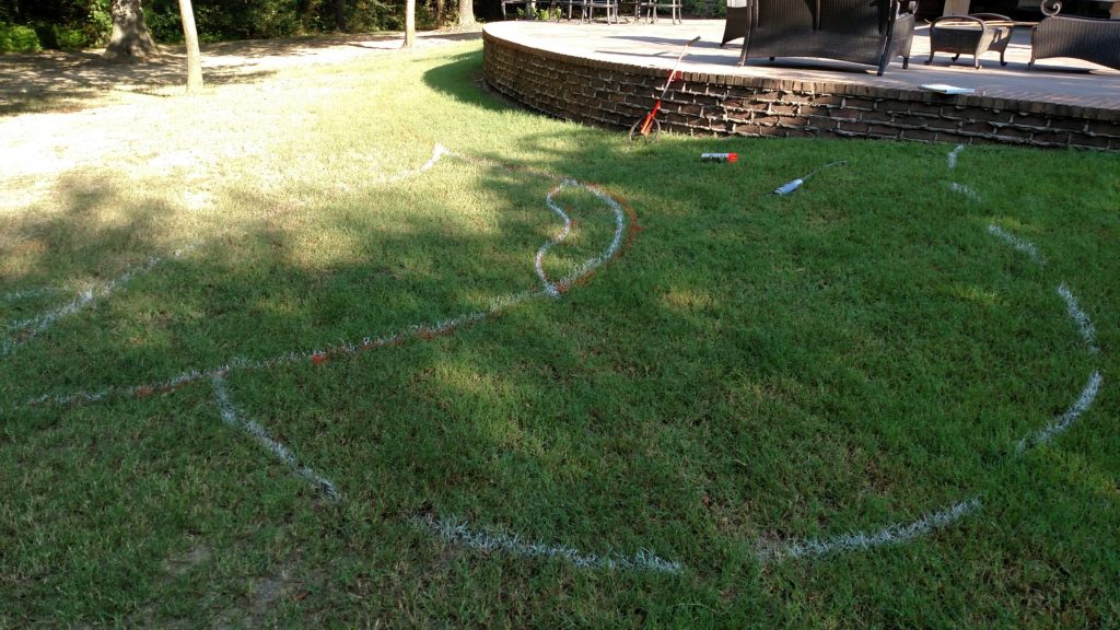 drawing out the pool design using spray paint in the grass